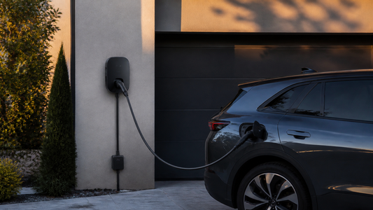 Borne de recharge 7,4 kW installée devant une maison avec voiture électrique branchée